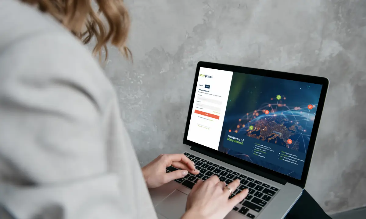 Travel agent logging into the StayGlobal accommodation booking platform on a laptop